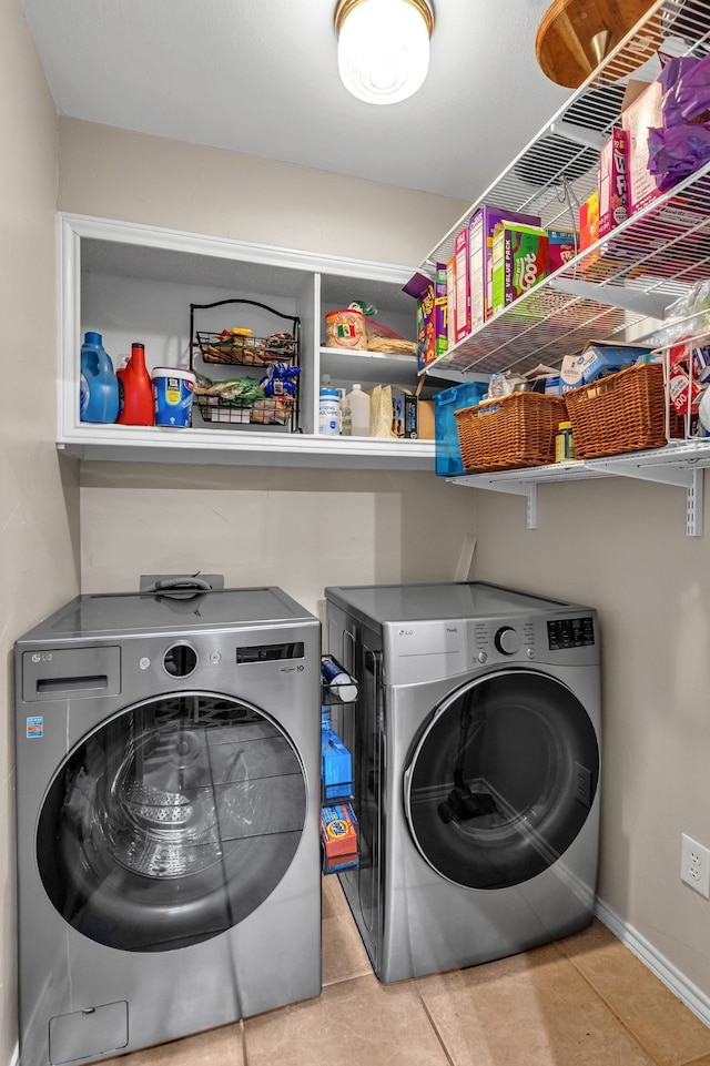 washroom with light tile patterned flooring and washer and dryer