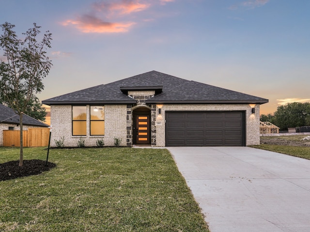 view of front of property featuring a yard and a garage