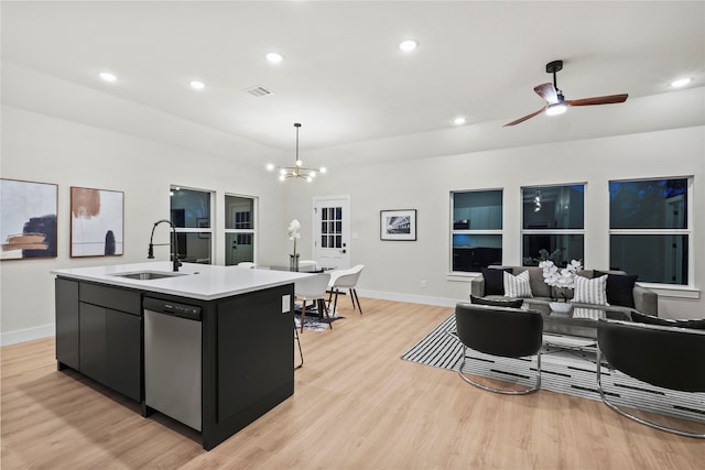 kitchen with pendant lighting, dishwasher, a kitchen island with sink, sink, and light hardwood / wood-style floors