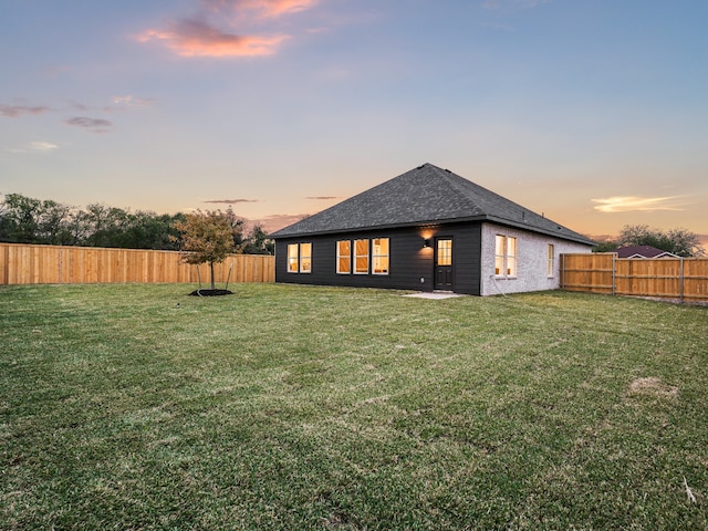 back house at dusk with a yard