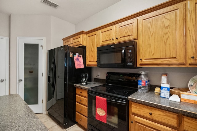 kitchen with black appliances and light tile patterned flooring