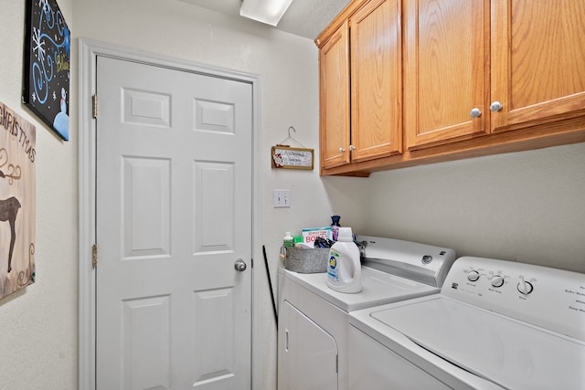 washroom featuring cabinets and independent washer and dryer