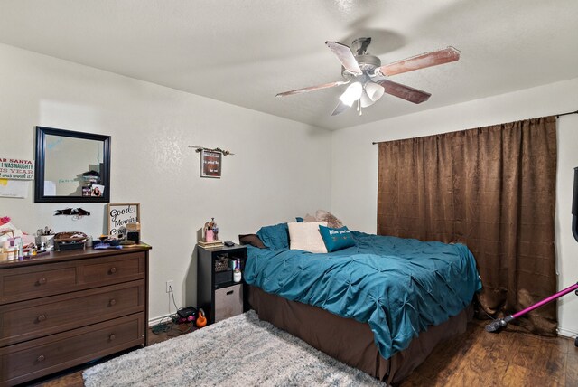 bedroom with ceiling fan and dark wood-type flooring