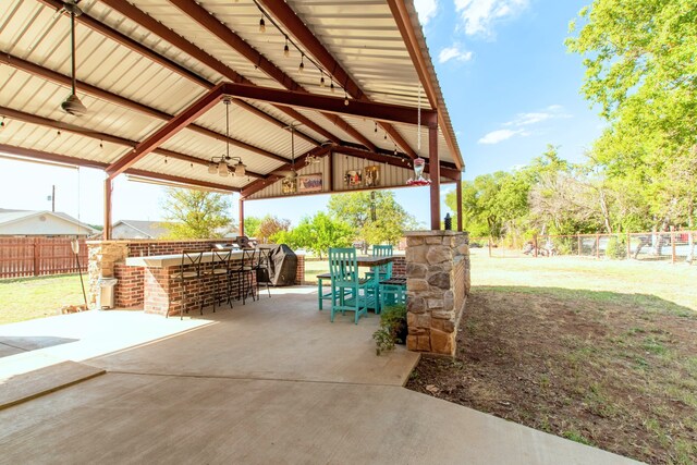 view of patio / terrace with a gazebo, ceiling fan, and exterior bar