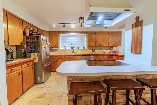 kitchen featuring sink, stainless steel appliances, tasteful backsplash, a breakfast bar area, and light tile patterned floors