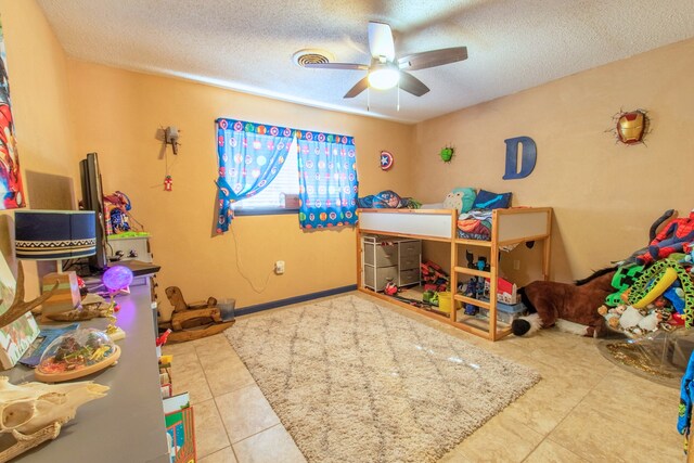 bedroom with tile patterned flooring, a textured ceiling, and ceiling fan