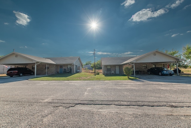 single story home featuring a carport and a front lawn