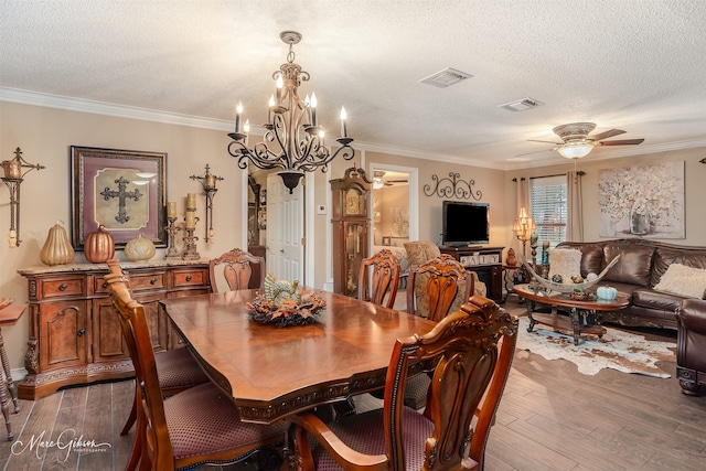 dining area featuring ceiling fan with notable chandelier, a textured ceiling, dark hardwood / wood-style flooring, and ornamental molding