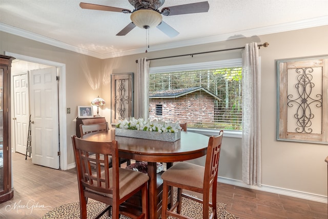 dining room with hardwood / wood-style floors, a textured ceiling, and crown molding