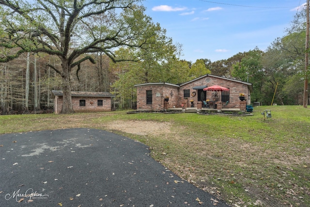 view of front of property featuring an outdoor structure and a front yard