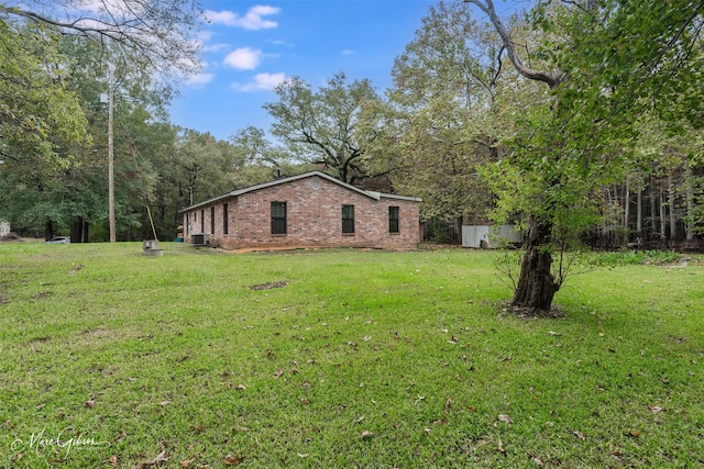 view of side of property featuring cooling unit and a lawn