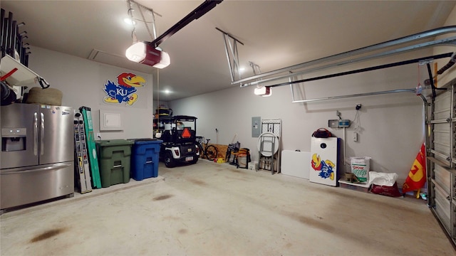 garage with stainless steel fridge, a garage door opener, and electric panel