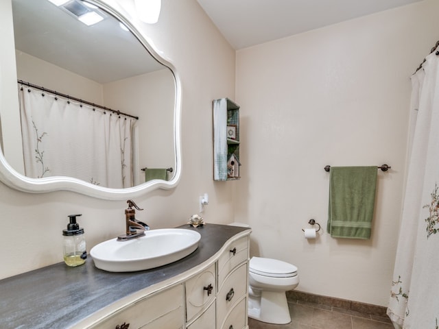 bathroom with tile patterned flooring, vanity, and toilet