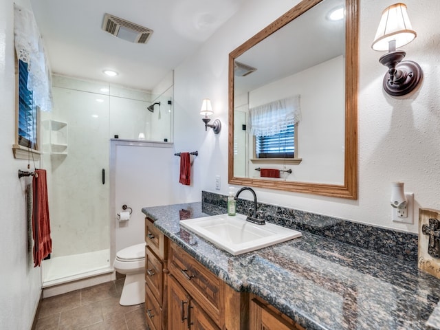 bathroom featuring tile patterned flooring, vanity, an enclosed shower, and toilet