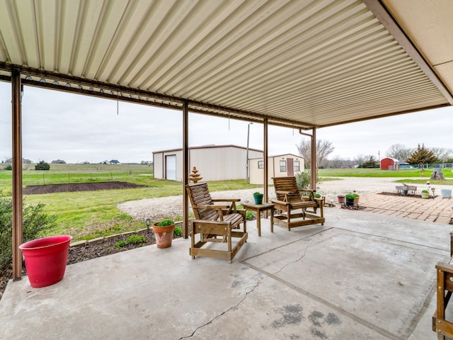 view of patio / terrace with a garage and an outbuilding