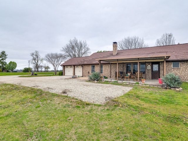 rear view of house with a garage and a lawn