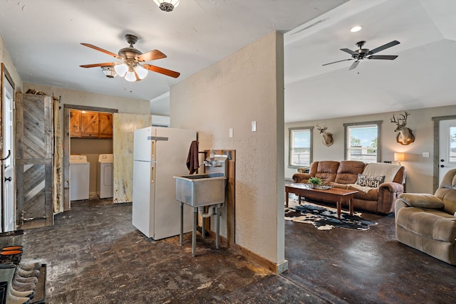 living room with separate washer and dryer, ceiling fan, sink, and vaulted ceiling