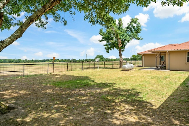 view of yard with a rural view and a patio