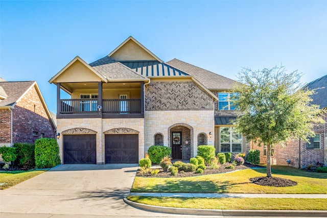 view of front of home featuring a balcony, a front lawn, and a garage