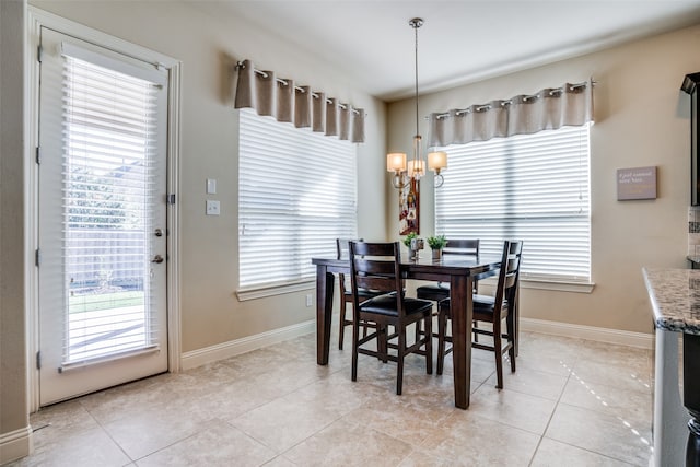 tiled dining area featuring an inviting chandelier