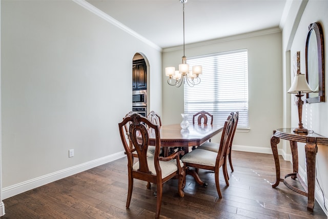 dining room featuring ornamental molding, an inviting chandelier, and dark wood-type flooring