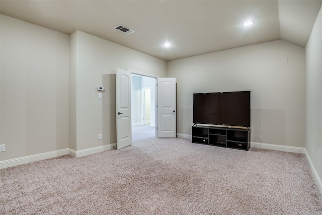 interior space with light colored carpet and lofted ceiling