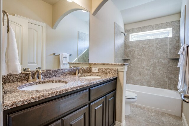 full bathroom featuring tile patterned flooring, toilet, vanity, and tiled shower / bath