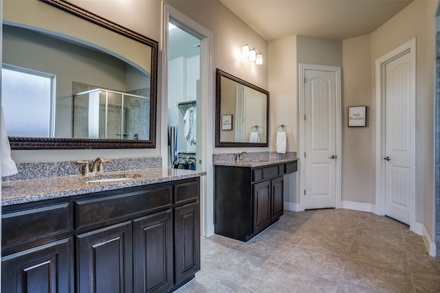 bathroom with tile patterned floors, vanity, and walk in shower