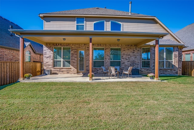 rear view of property featuring a patio area and a lawn