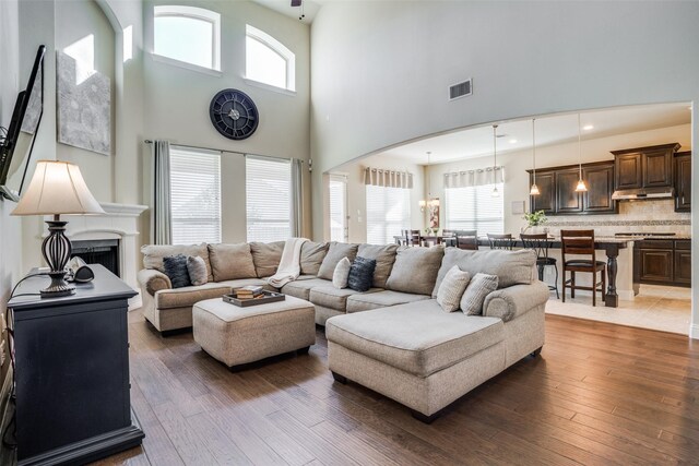 living room with a high ceiling, dark hardwood / wood-style flooring, and a wealth of natural light