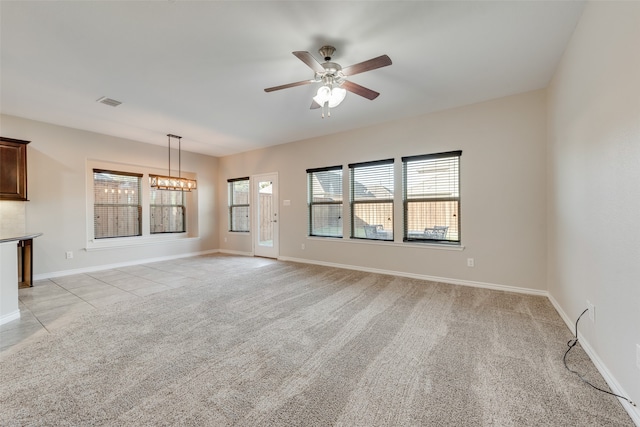 unfurnished living room with ceiling fan with notable chandelier and light colored carpet