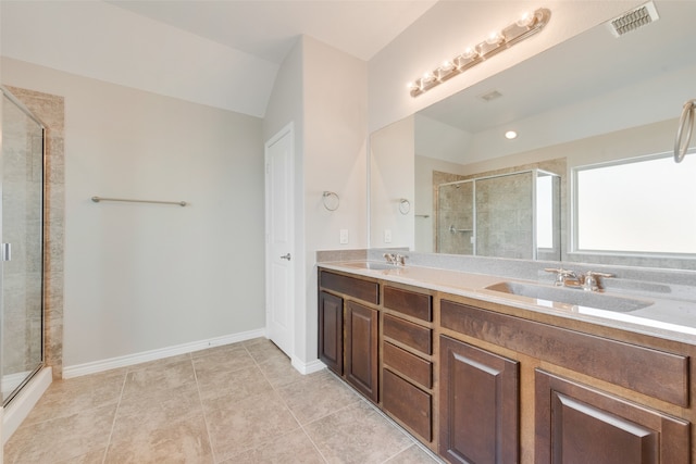 bathroom with tile patterned flooring, vanity, lofted ceiling, and walk in shower