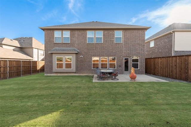 rear view of property featuring a yard and a patio