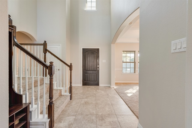 carpeted foyer entrance featuring a high ceiling