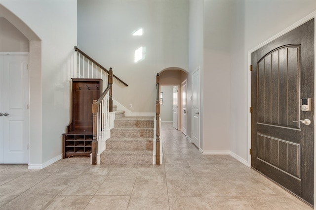 tiled foyer entrance with a towering ceiling