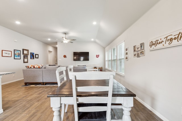 dining area featuring hardwood / wood-style flooring, vaulted ceiling, and ceiling fan