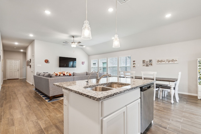 kitchen featuring dishwasher, sink, lofted ceiling, a center island with sink, and white cabinets