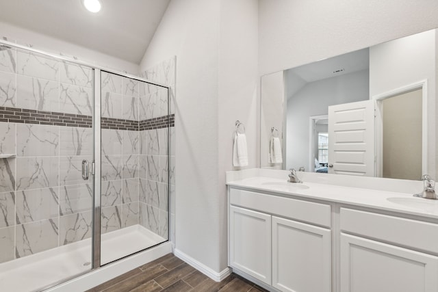 bathroom with hardwood / wood-style floors, vanity, walk in shower, and vaulted ceiling