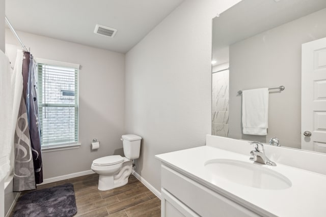 bathroom with vanity, wood-type flooring, and toilet