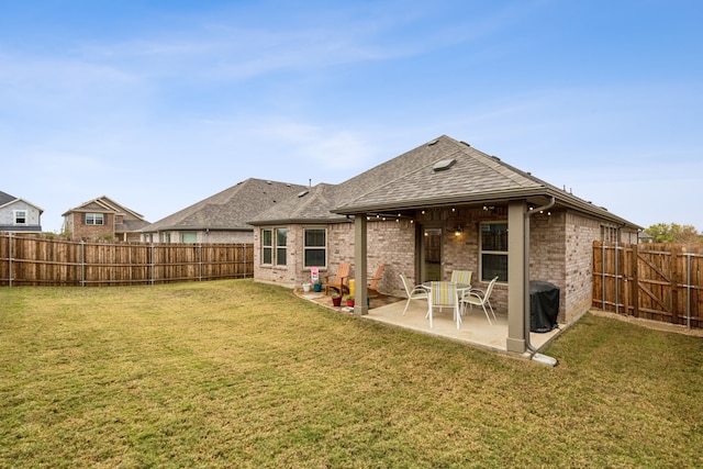 rear view of property featuring a patio and a lawn