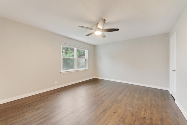 empty room with ceiling fan and dark hardwood / wood-style flooring