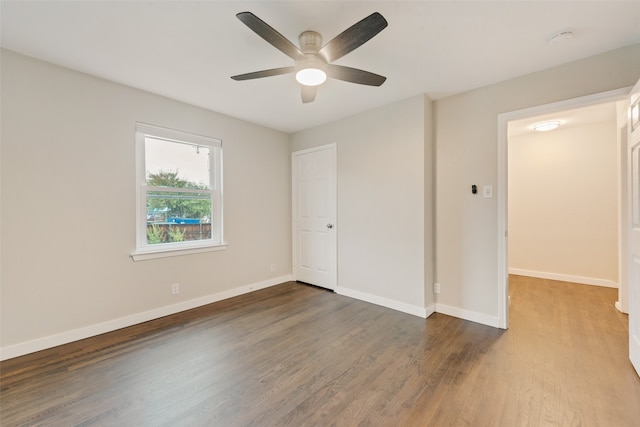 unfurnished bedroom with ceiling fan, dark hardwood / wood-style flooring, and a closet