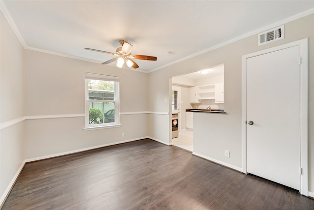 empty room featuring dark hardwood / wood-style floors, ceiling fan, and crown molding