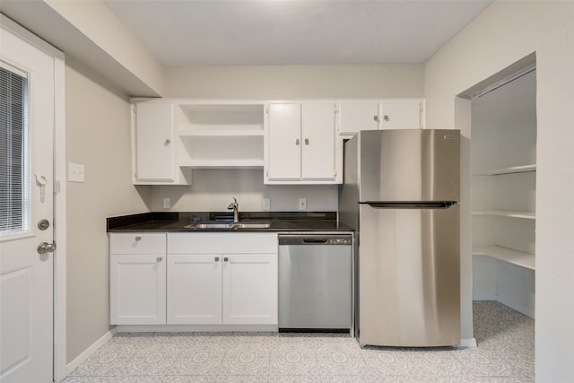 kitchen featuring stainless steel appliances, white cabinetry, and sink