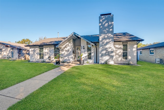 view of front of home with central AC and a front lawn