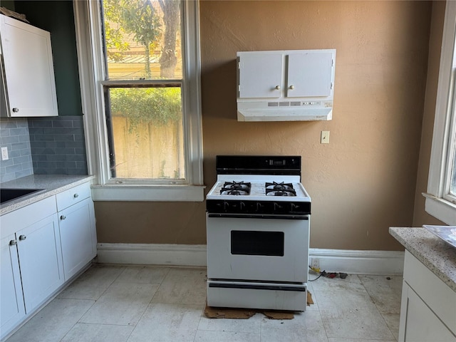 kitchen with backsplash, white cabinetry, extractor fan, and white gas range