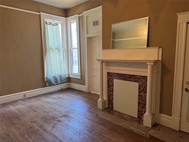 unfurnished living room featuring hardwood / wood-style floors, a healthy amount of sunlight, and a fireplace