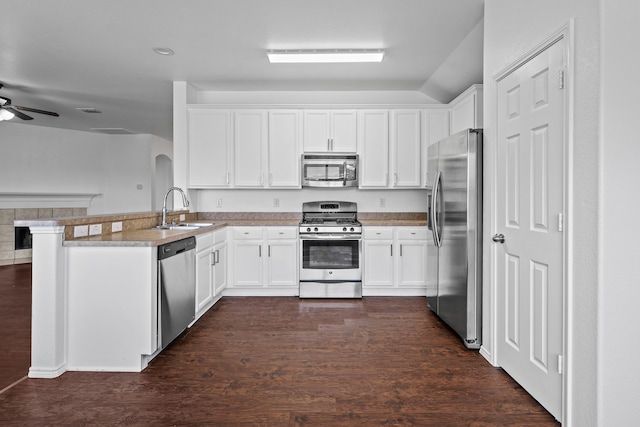 kitchen with white cabinetry, sink, dark hardwood / wood-style flooring, kitchen peninsula, and appliances with stainless steel finishes