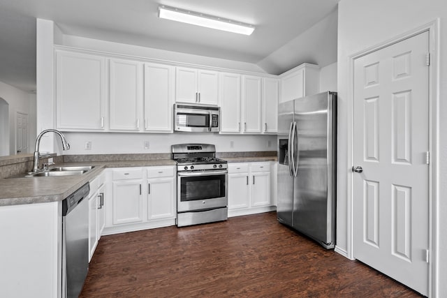 kitchen with white cabinets, appliances with stainless steel finishes, dark hardwood / wood-style flooring, and sink