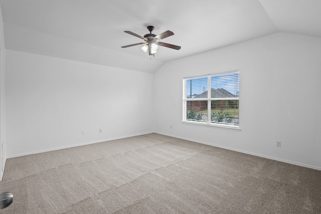 carpeted empty room featuring vaulted ceiling and ceiling fan